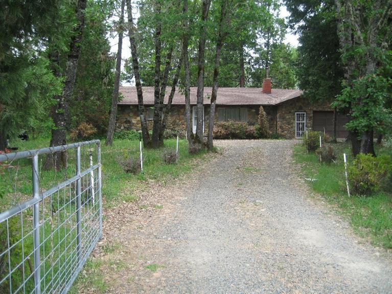 4988 Holland Loop Road Cave Junction, OR 97523 - Photo 2 of 35 a front view of a house with a garden