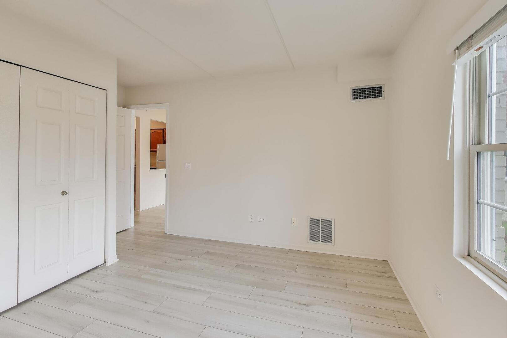 1220 Depot Street, Unit 109 Glenview, IL 60025 - Photo 15 of 35 a view of an empty room with wooden floor and a window
