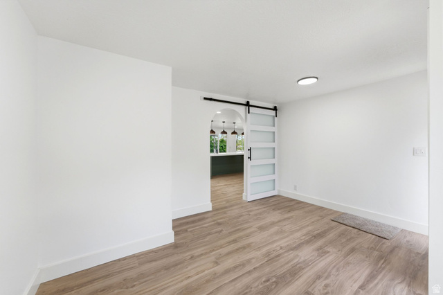871 Bonita Way Centerville, UT 84014 - Photo 24 of 61 Spacious interior room featuring wood-finish flooring and a contemporary white barn door with frosted glass panels