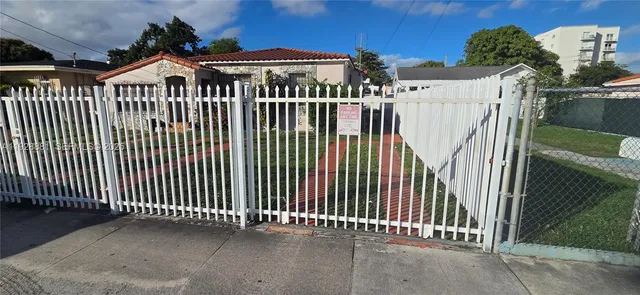 a front view of a house with iron fence