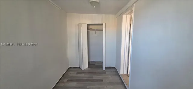 an empty room with chandelier fan