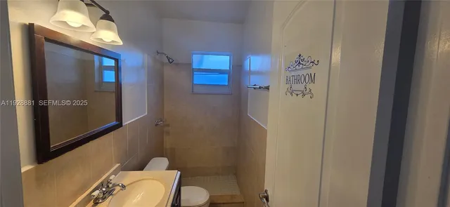 a view of an empty room with closet and a window