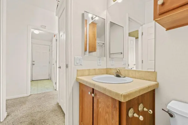 a view of an empty room with window and a kitchen