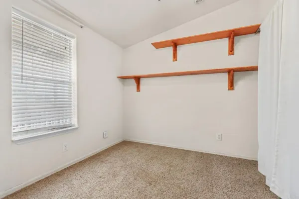 a furnished livingroom with a ceiling fan and window