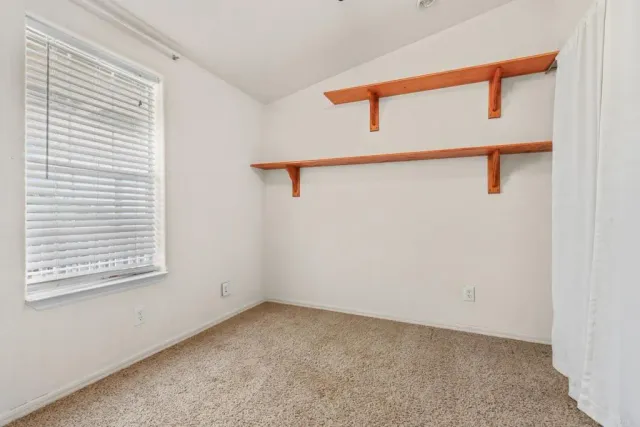 a furnished livingroom with a ceiling fan and window