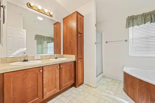 a kitchen with stainless steel appliances granite countertop a stove top oven a sink dishwasher and a refrigerator with wooden cabinets