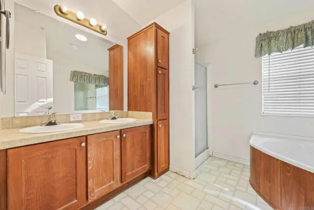 a kitchen with stainless steel appliances granite countertop a stove top oven a sink dishwasher and a refrigerator with wooden cabinets