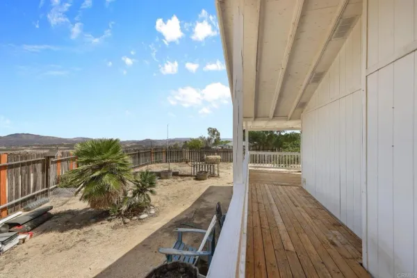 a view of a roof deck with wooden fence and floor