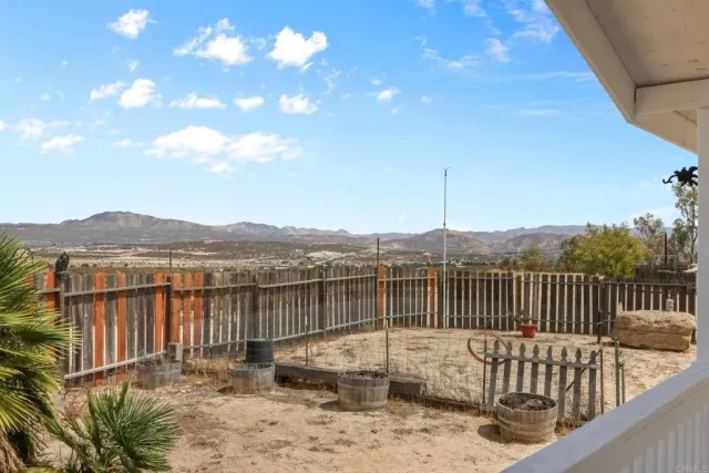 a view of a yard with wooden fence
