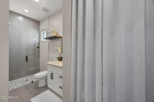 a bathroom with a toilet a sink and a large mirror