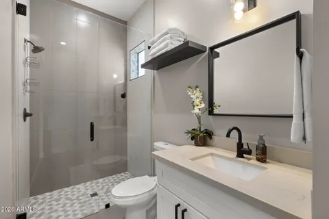 a bathroom with a sink a toilet and shower