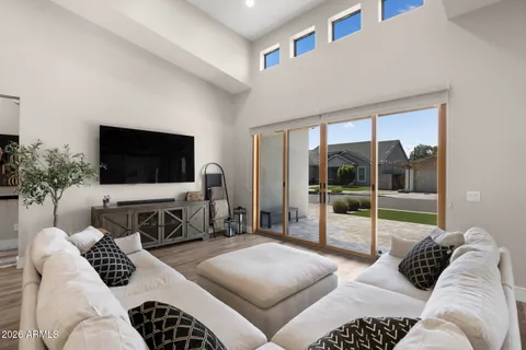 a living room with furniture a flat screen tv and a floor to ceiling window