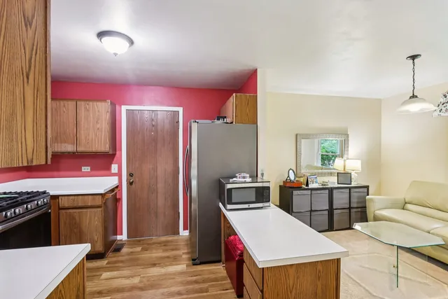 a kitchen with stainless steel appliances kitchen island granite countertop a stove and a refrigerator