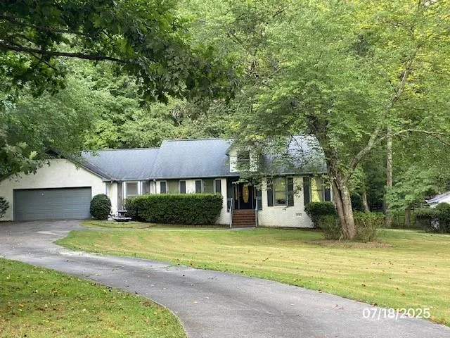a front view of a house with a yard and potted plants