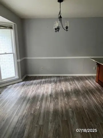 a view of a room with wooden floor and windows