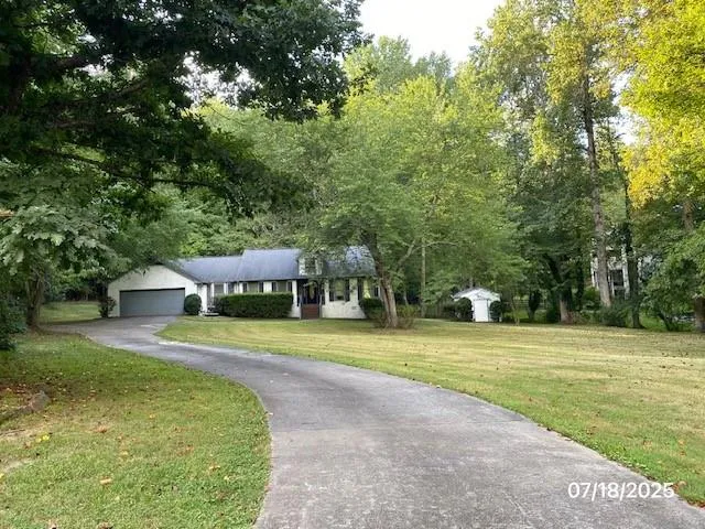 a front view of a house with a yard and trees