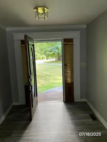 a view of a hallway with wooden floor and a porch