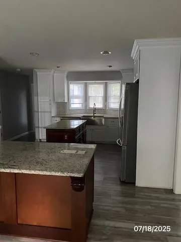 a kitchen with stainless steel appliances granite countertop a sink stove and refrigerator