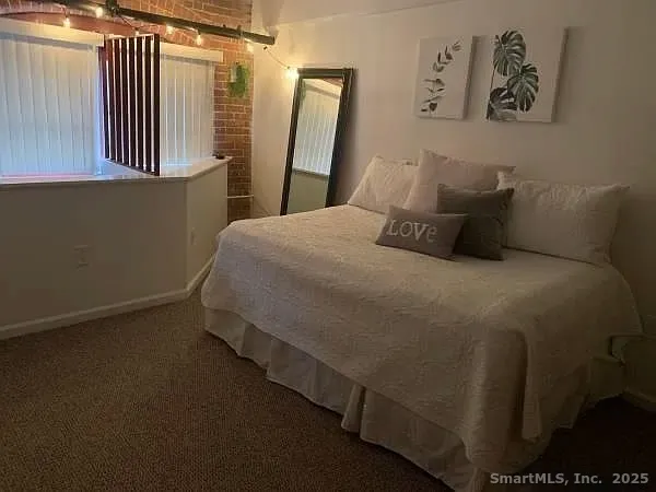 a bedroom with a bed and painting on the wall