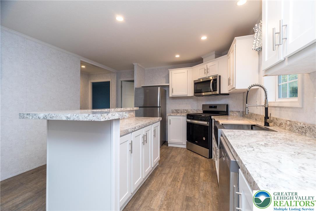 465 Royal Manor Road, Unit LOT 6 Easton, PA 18042 - Photo 3 of 25 a large kitchen with kitchen island granite countertop a stove top oven a sink a counter space and cabinets