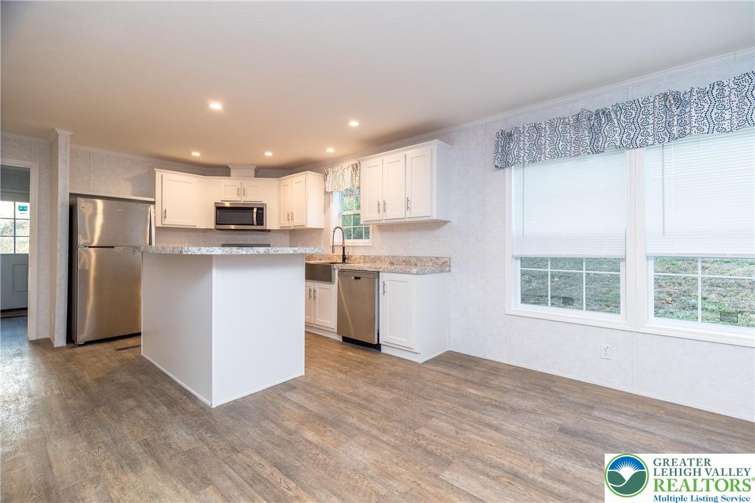 465 Royal Manor Road, Unit LOT 6 Easton, PA 18042 - Photo 4 of 25 a kitchen with stainless steel appliances granite countertop a stove a refrigerator a sink a microwave oven with wooden floor and cabinets