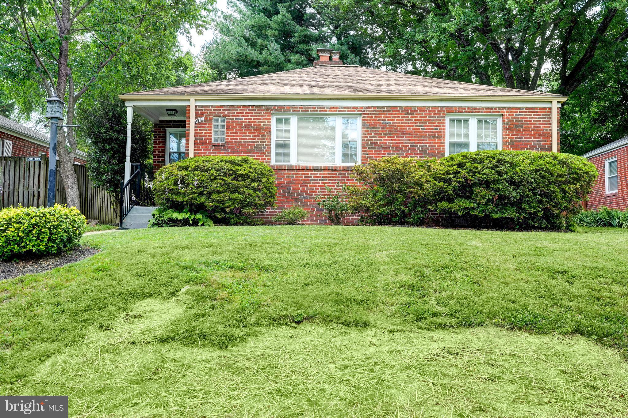 a front view of a house with yard and green space