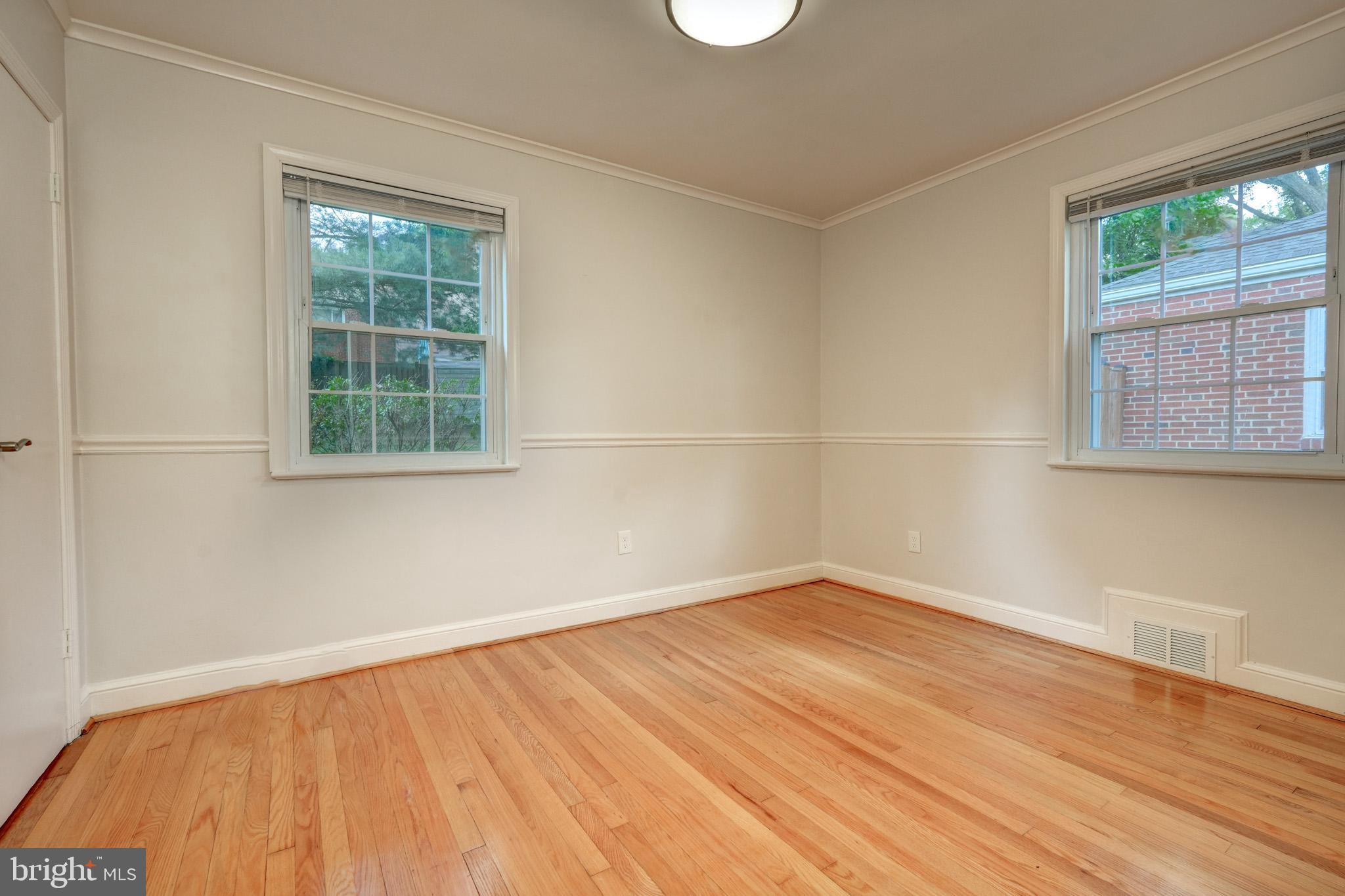 9912 Markham Street Silver Spring, MD 20901 - Photo 14 of 28 an empty room with wooden floor and windows