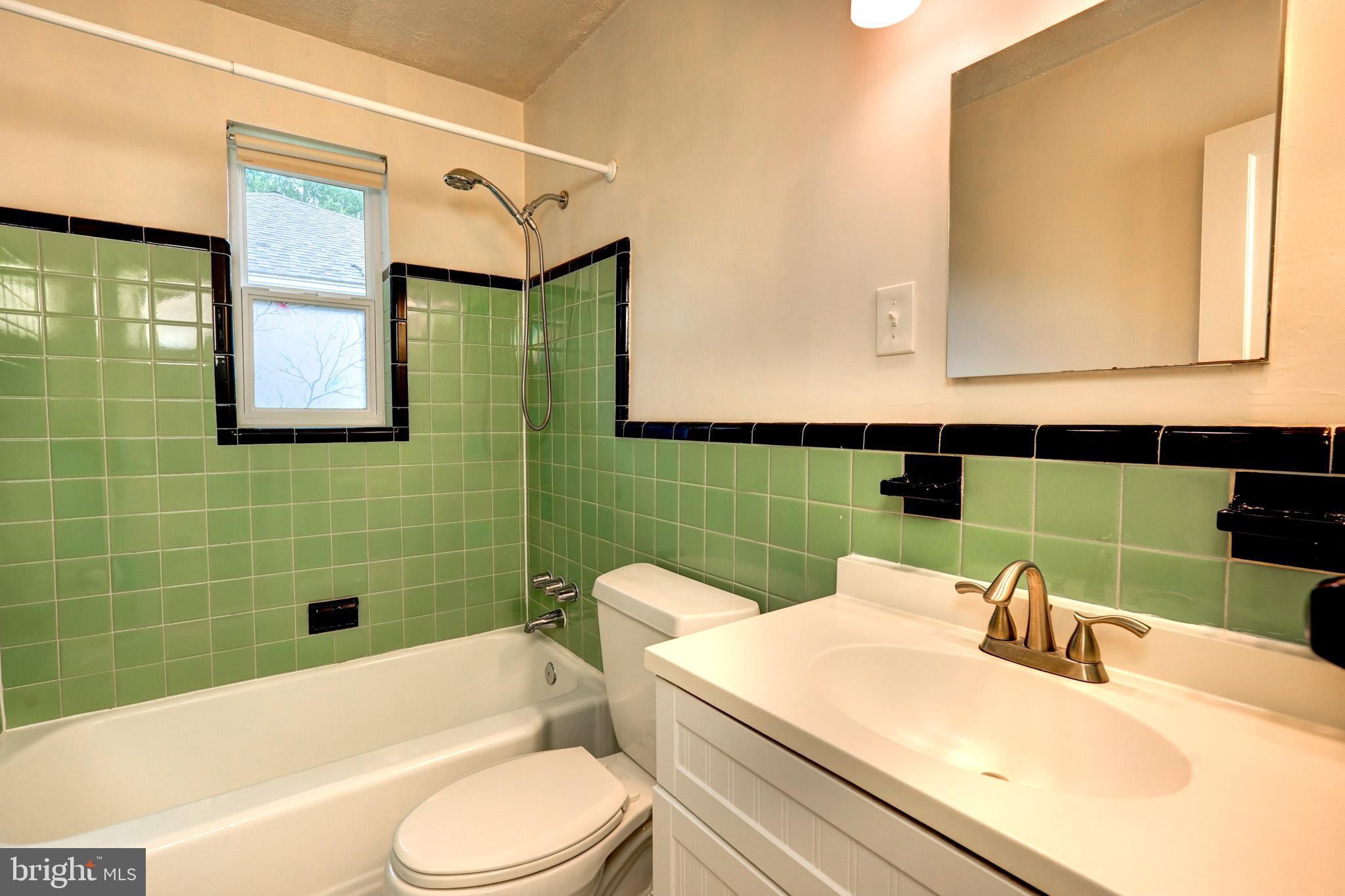 9912 Markham Street Silver Spring, MD 20901 - Photo 18 of 28 a bathroom with a sink a toilet and mirror