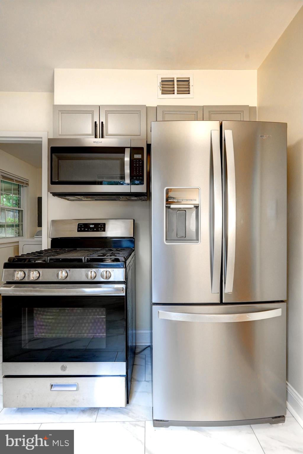 9912 Markham Street Silver Spring, MD 20901 - Photo 23 of 28 a metallic refrigerator freezer sitting inside of a kitchen