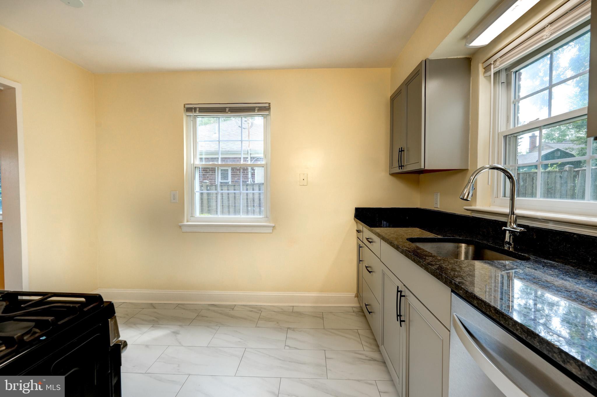 9912 Markham Street Silver Spring, MD 20901 - Photo 24 of 28 a kitchen that has a sink and a stove