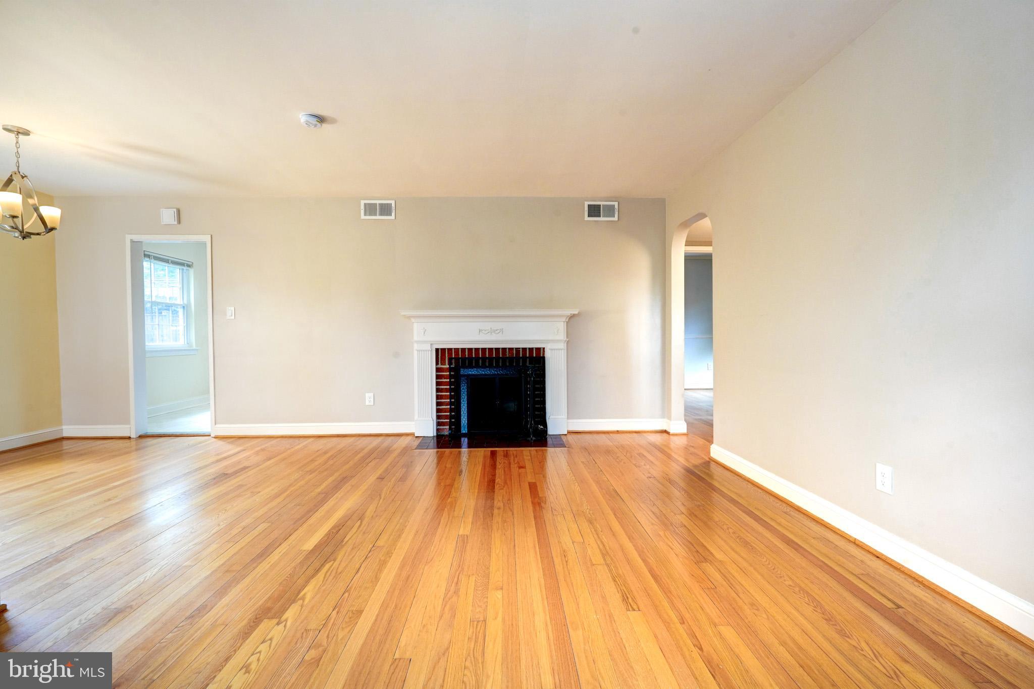 9912 Markham Street Silver Spring, MD 20901 - Photo 5 of 28 a view of empty room with wooden floor and fireplace