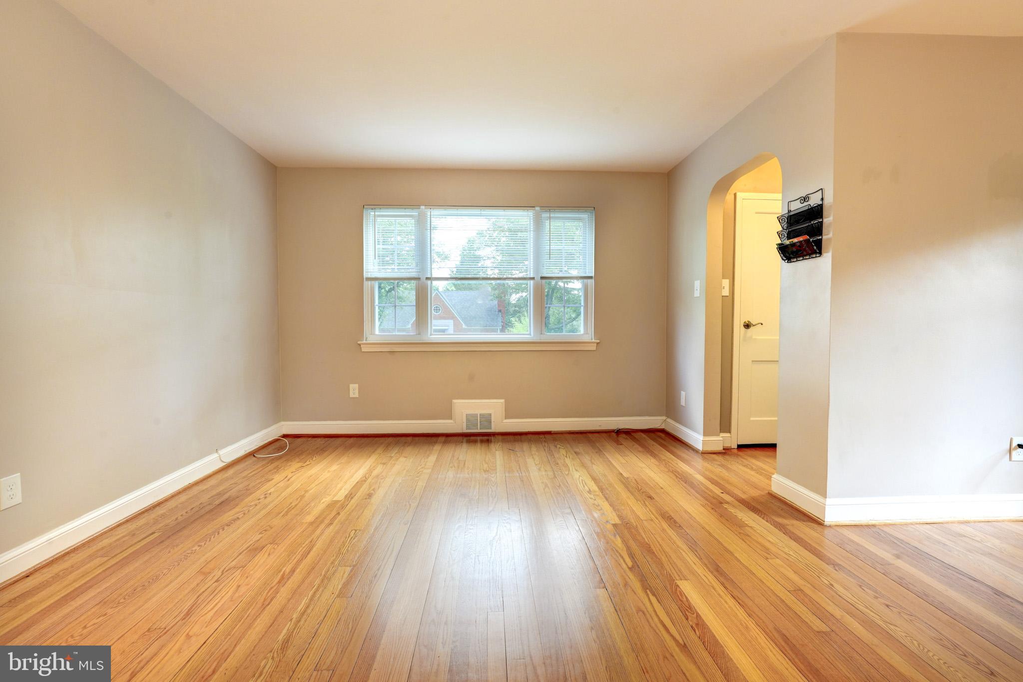 9912 Markham Street Silver Spring, MD 20901 - Photo 7 of 28 an empty room with wooden floor and windows