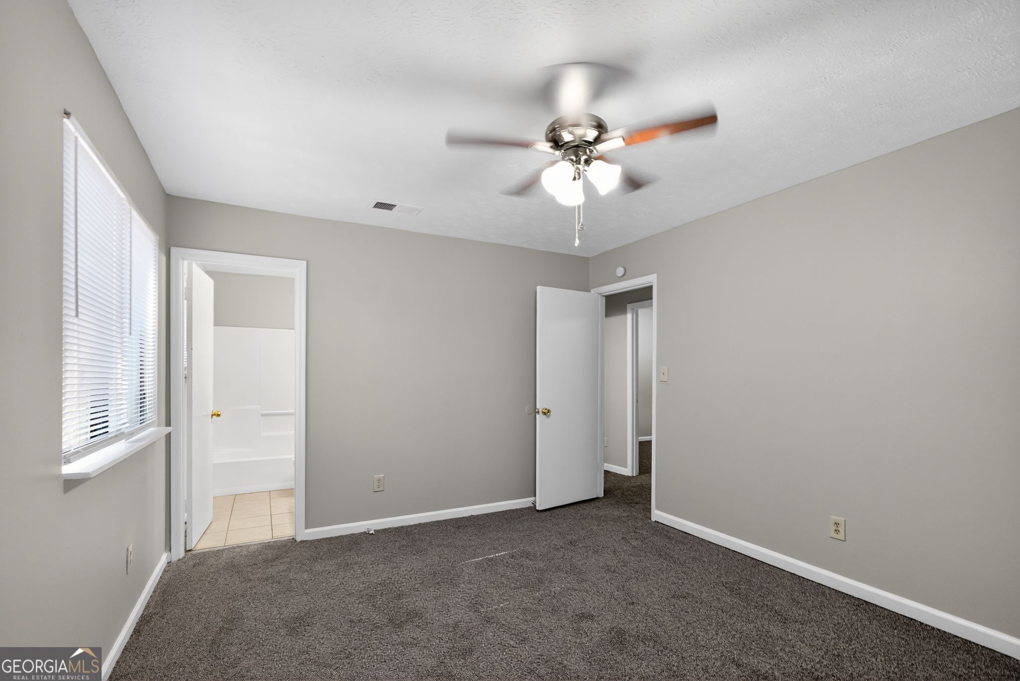 5515 Rock Springs Road Lithonia, GA 30038 - Photo 21 of 34 an empty room with a ceiling fan and a window