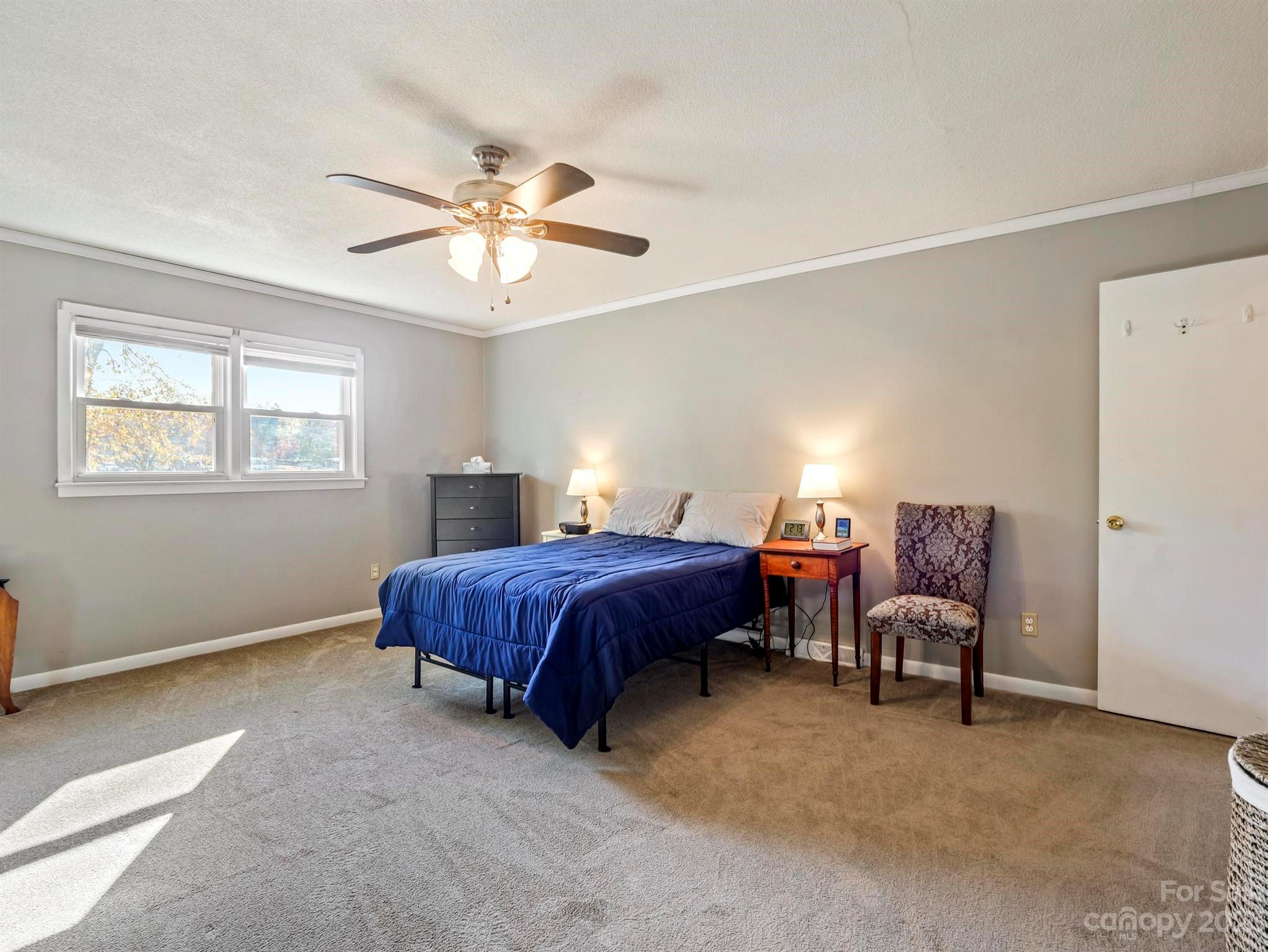 979 High Shoals Church Road Mooresboro, NC 28114 - Photo 23 of 34 a spacious bedroom with a bed and a chandelier