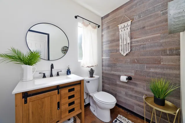 a bathroom with a granite countertop sink a toilet and a mirror