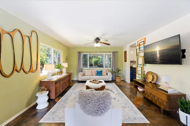 a living room with furniture tv and a large window
