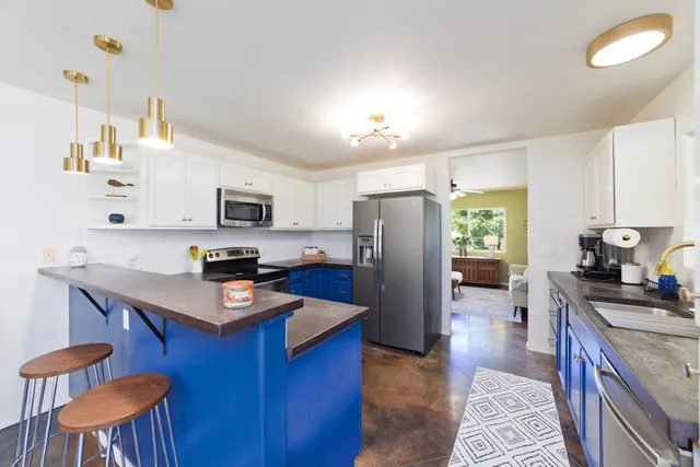 a kitchen with stainless steel appliances a stove refrigerator sink microwave and cabinets