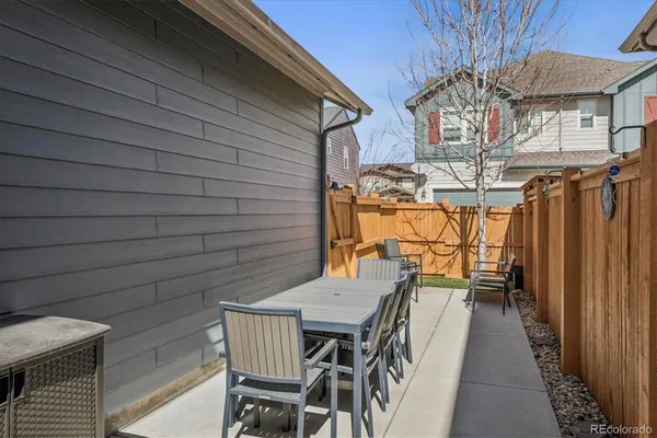 a view of a patio with table and chairs with wooden floor and fence