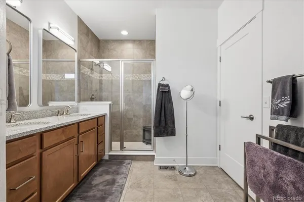 a bathroom with a double vanity sink a mirror and a shower