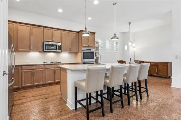 a kitchen with stainless steel appliances kitchen island granite countertop a sink a microwave a stove and a refrigerator