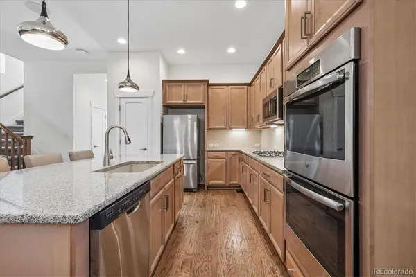 a kitchen with granite countertop a sink and refrigerator