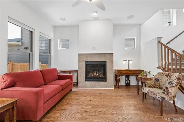 a living room with furniture a fireplace and a large window