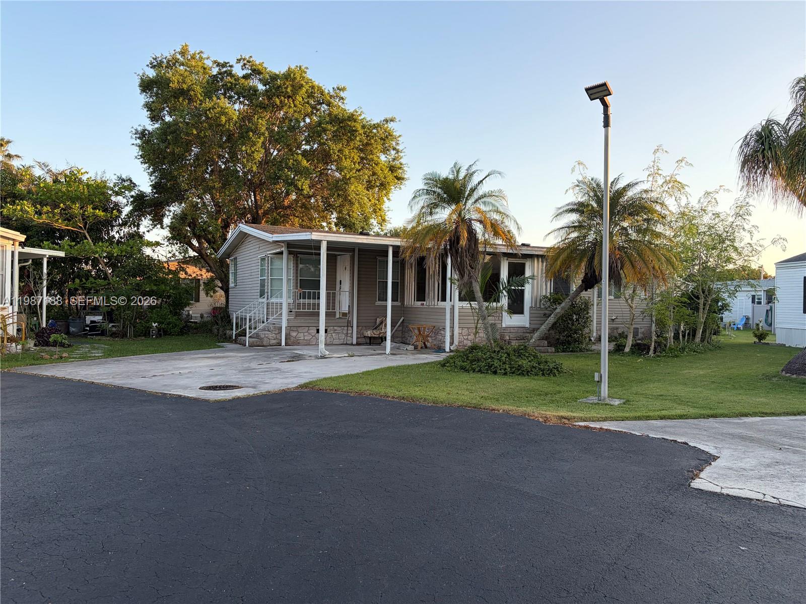 35303 Southwest 180th Avenue, Unit 391 Homestead, FL 33034 - Photo 1 of 23 a front view of house with yard and green space