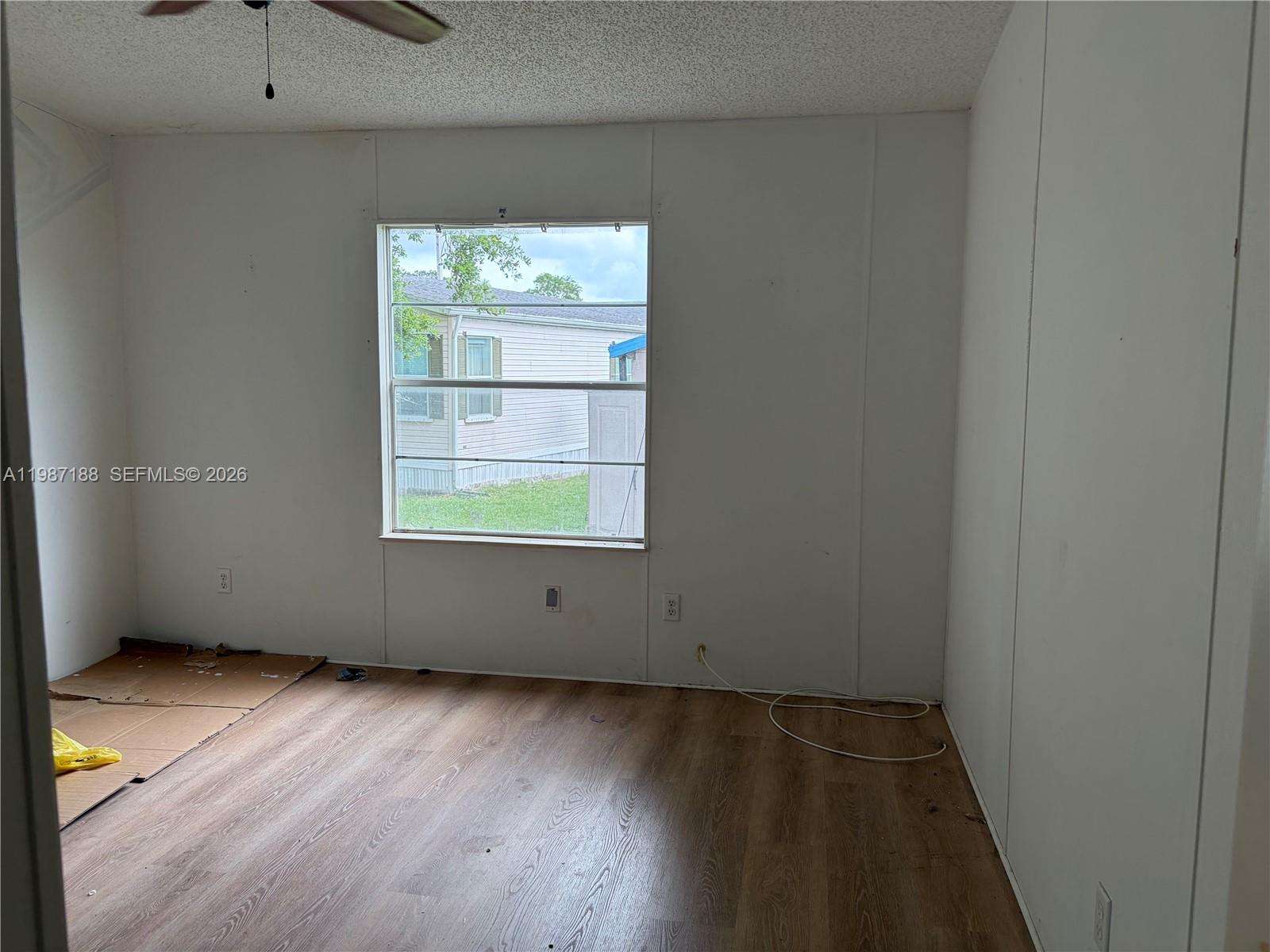 35303 Southwest 180th Avenue, Unit 391 Homestead, FL 33034 - Photo 12 of 23 an empty room with wooden floor and windows