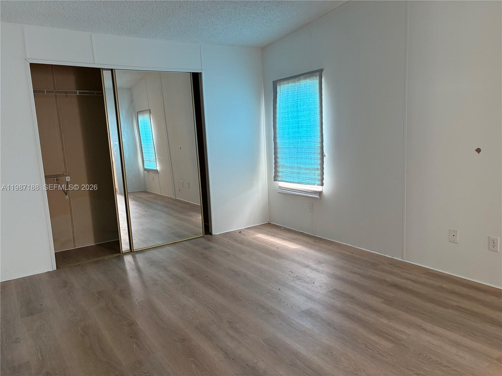 35303 Southwest 180th Avenue, Unit 391 Homestead, FL 33034 - Photo 16 of 23 an empty room with wooden floor and a window