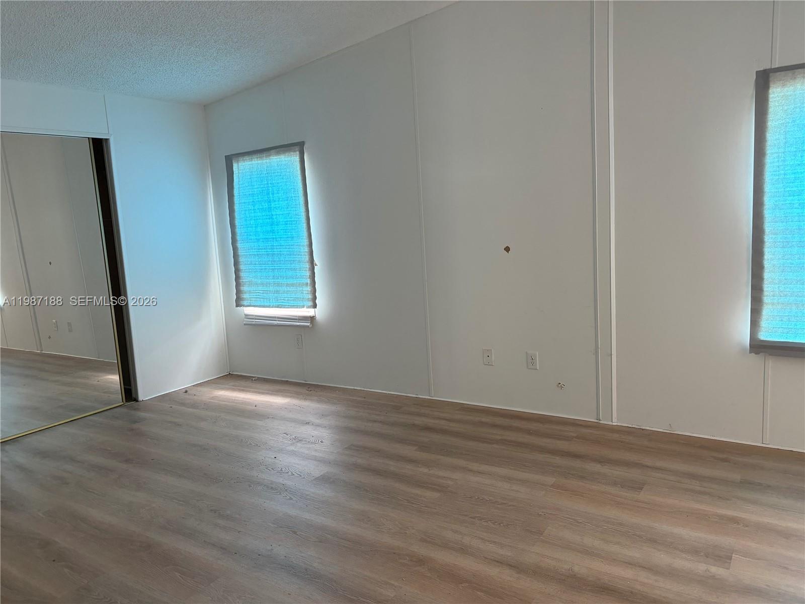 35303 Southwest 180th Avenue, Unit 391 Homestead, FL 33034 - Photo 17 of 23 an empty room with wooden floor and windows