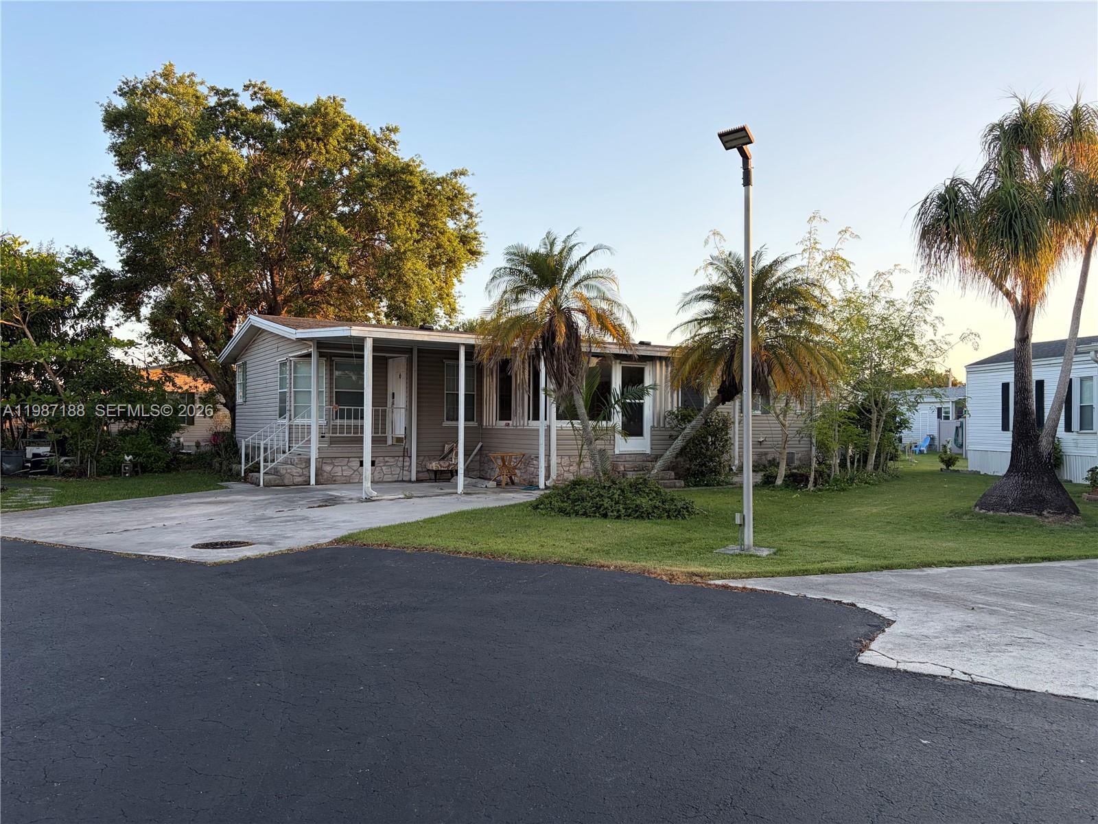 35303 Southwest 180th Avenue, Unit 391 Homestead, FL 33034 - Photo 2 of 23 a front view of a house with a yard and garage