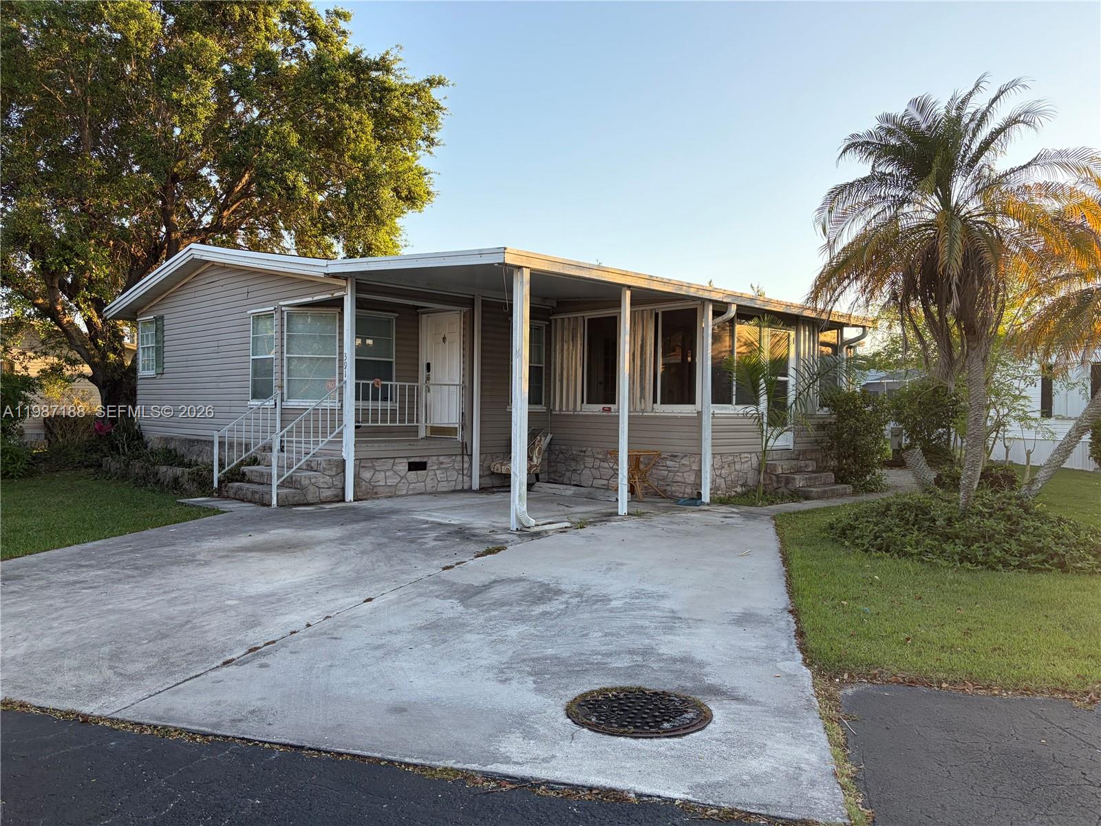 35303 Southwest 180th Avenue, Unit 391 Homestead, FL 33034 - Photo 9 of 23 a view of a house with a yard and garage