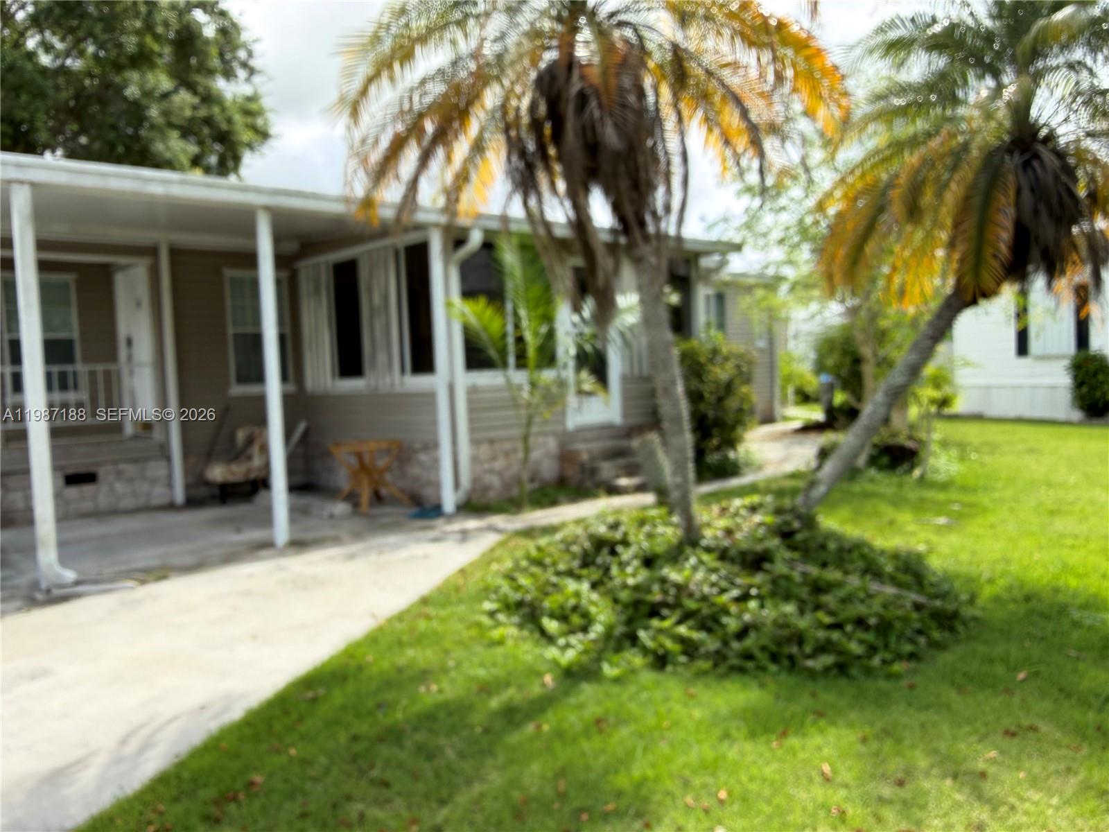 35303 Southwest 180th Avenue, Unit 391 Homestead, FL 33034 - Photo 10 of 23 a view of a house with a yard and tree s