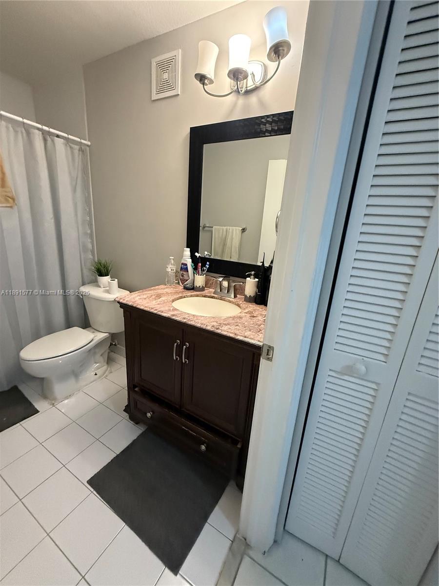 7145 Northwest 173rd Drive, Unit 1106 Hialeah, FL 33015 - Photo 14 of 17 a bathroom with a sink a toilet and mirror